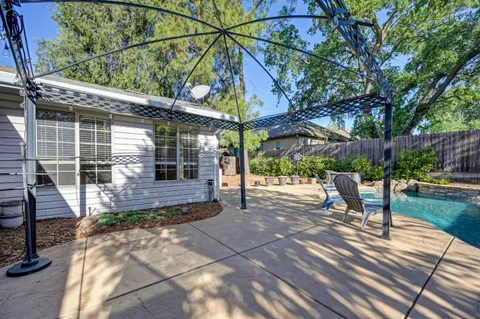 a view of a house with backyard and sitting area