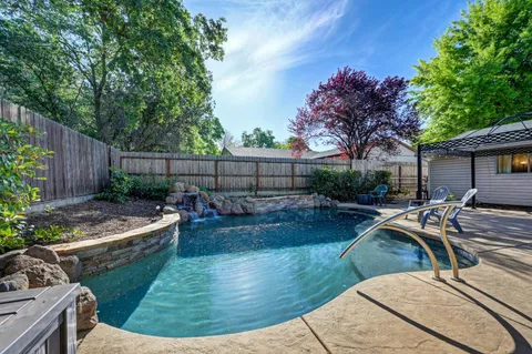 a view of a backyard and swimming pool