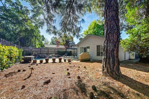 a view of a house with backyard and a tree