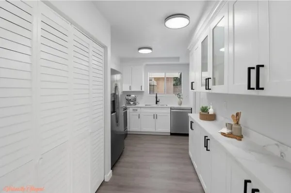 a kitchen with white cabinets and white appliances
