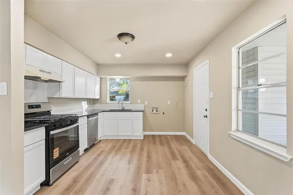 a kitchen with wooden floors and appliances