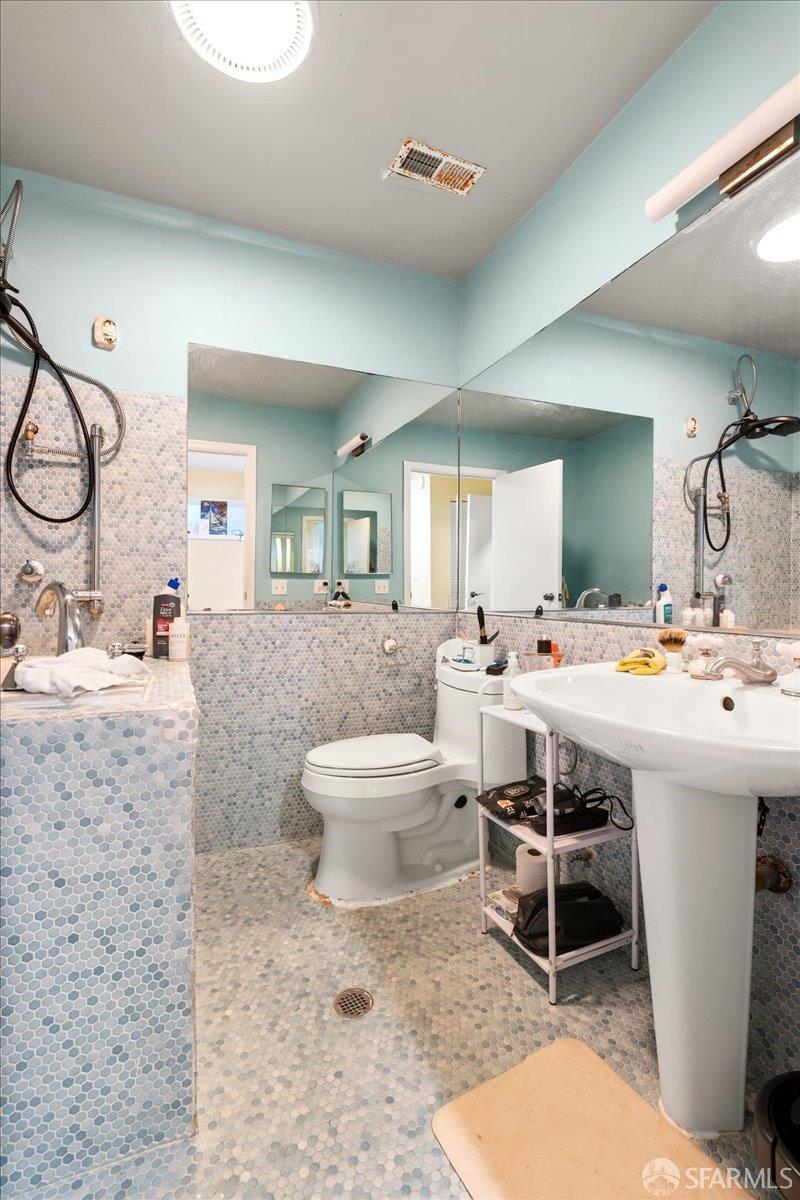 130 Ripley Street San Francisco, CA 94110 - Photo 37 of 69 a bathroom with a sink mirror vanity and toilet