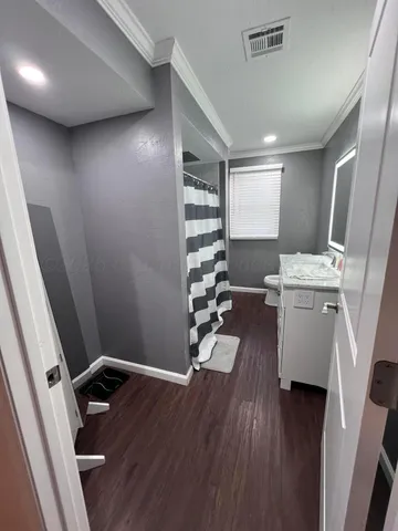 a view of a hallway with workspace and wooden floor