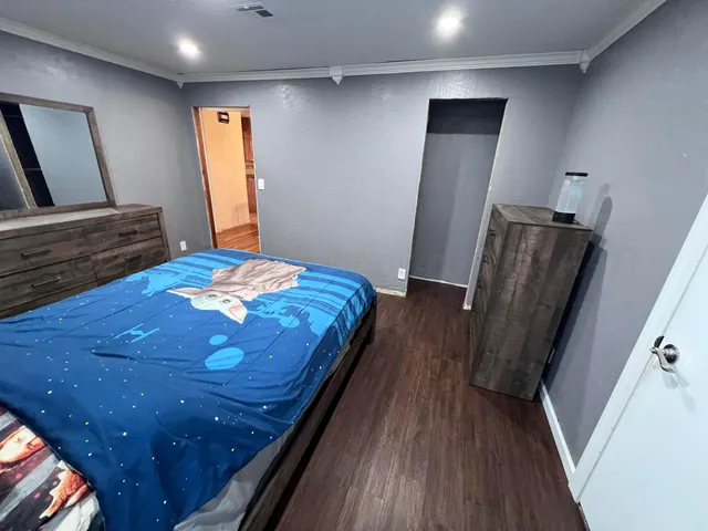 a bedroom with a bed and a mirror on dresser
