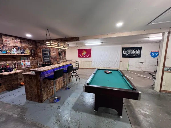 a room with pool table and windows