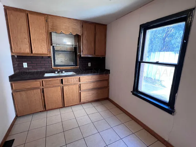 a kitchen with stainless steel appliances a sink cabinets and a window