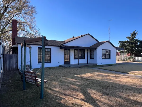 a front view of a house with a yard and seating space