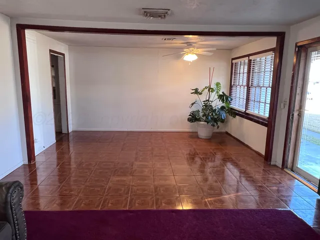 a view of a hallway with wooden floor and a mirror