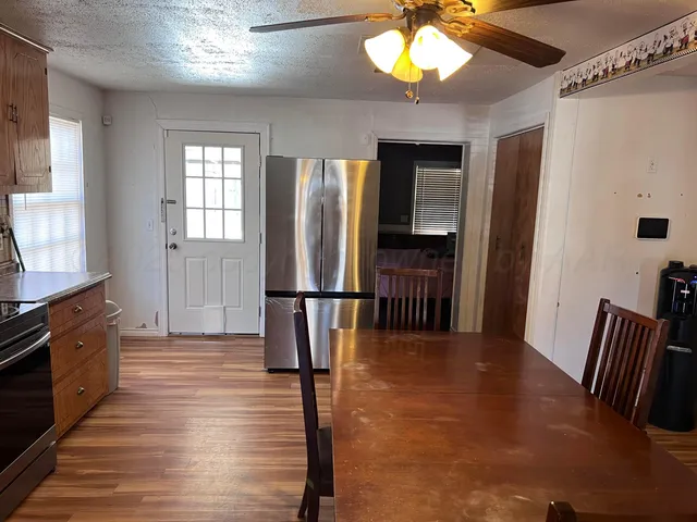 a kitchen with stainless steel appliances wooden floor and large window