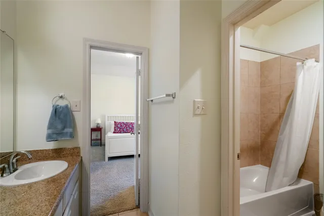 a en suite bathroom with a granite countertop tub sink and mirror