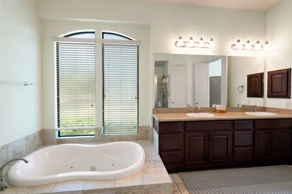 a bathroom with a tub sink and mirror