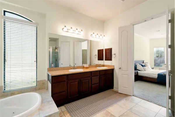 a spacious bathroom with a tub sink and mirror