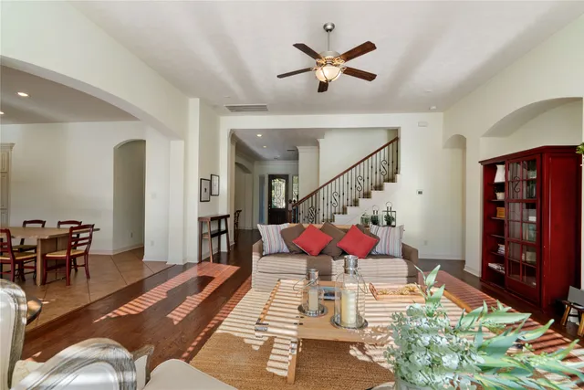a living room with furniture kitchen view and a chandelier
