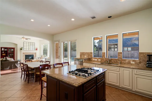 a kitchen with a stove a sink a refrigerator and a dining table