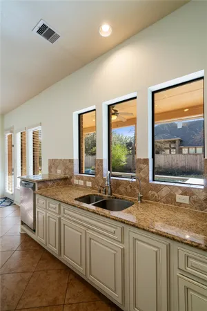 a kitchen with granite countertop a sink stove and refrigerator