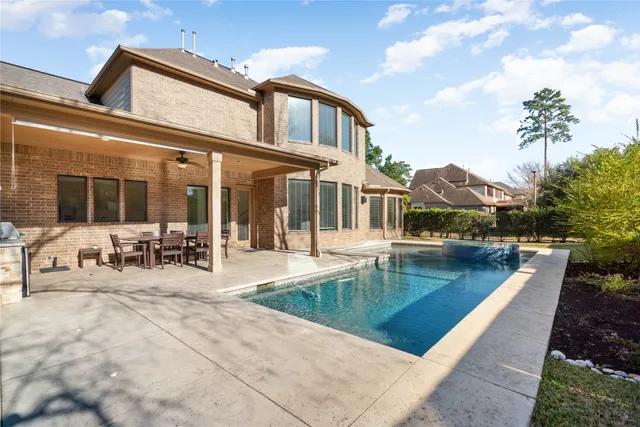 a view of a house with swimming pool and sitting area