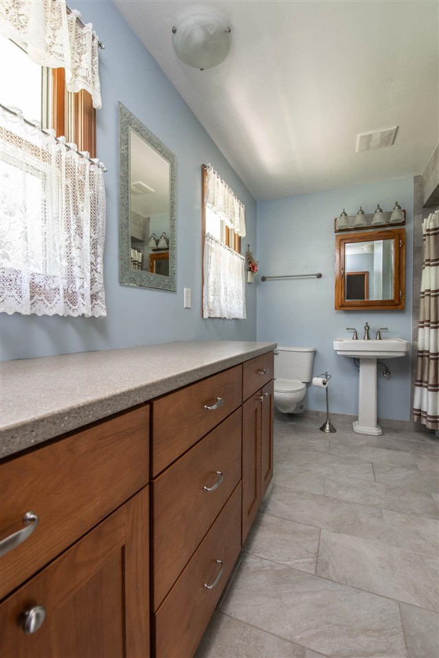 4960 Welsh Road Rockford, IL 61107 - Photo 20 of 39 a spacious bathroom with a double vanity sink a mirror and a bathtub