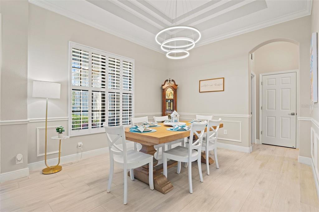 6470 Indigo Bunting Place Lakewood Ranch, FL 34202 - Photo 16 of 65 a view of a dining room with furniture and wooden floor