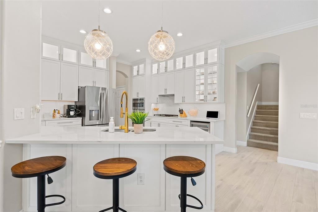 6470 Indigo Bunting Place Lakewood Ranch, FL 34202 - Photo 23 of 65 a kitchen with stainless steel appliances granite countertop a sink a stove and a dining table with wooden floor