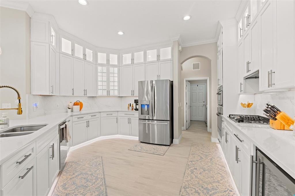 6470 Indigo Bunting Place Lakewood Ranch, FL 34202 - Photo 24 of 65 a kitchen with a refrigerator sink and cabinets