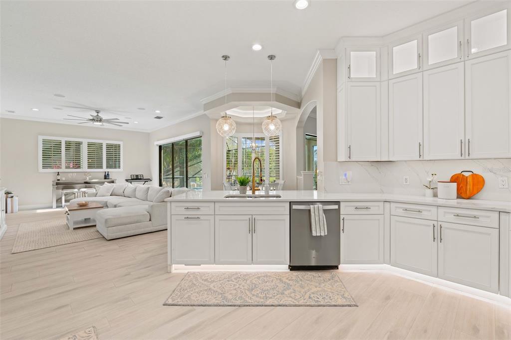 6470 Indigo Bunting Place Lakewood Ranch, FL 34202 - Photo 3 of 65 a large white kitchen with a white cabinets and wooden floor