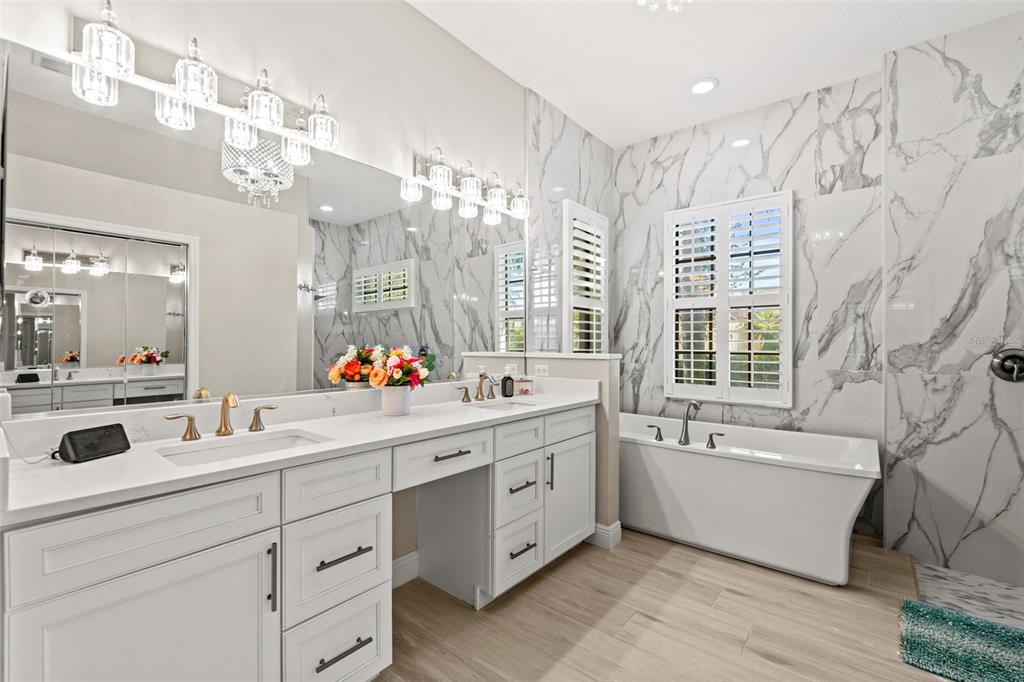 6470 Indigo Bunting Place Lakewood Ranch, FL 34202 - Photo 32 of 65 a bathroom with a double vanity sink mirror bathtub and shower