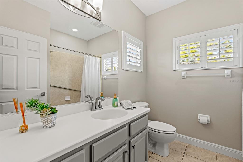 6470 Indigo Bunting Place Lakewood Ranch, FL 34202 - Photo 46 of 65 a bathroom with a granite countertop sink a large mirror a toilet and a window