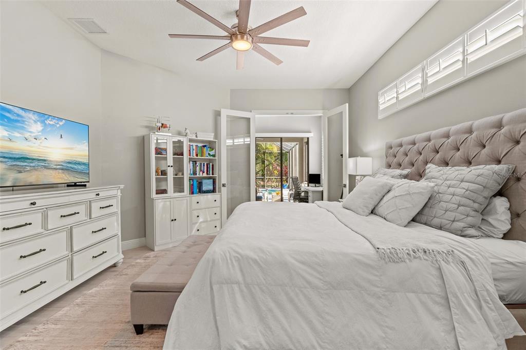 6470 Indigo Bunting Place Lakewood Ranch, FL 34202 - Photo 6 of 65 a bedroom with a large bed and a flat screen tv