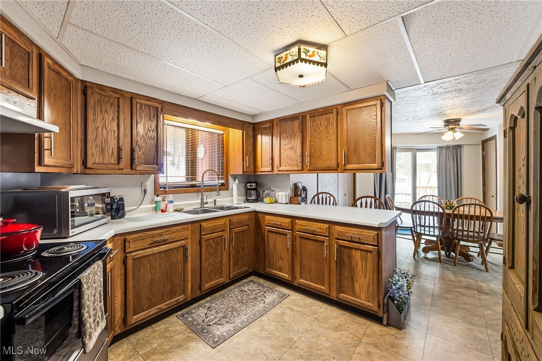 86523 North Bay Road Scio, OH 43988 - Photo 9 of 25 Kitchen featuring a peninsula, light countertops, brown cabinetry, stainless steel microwave, and plenty of natural light