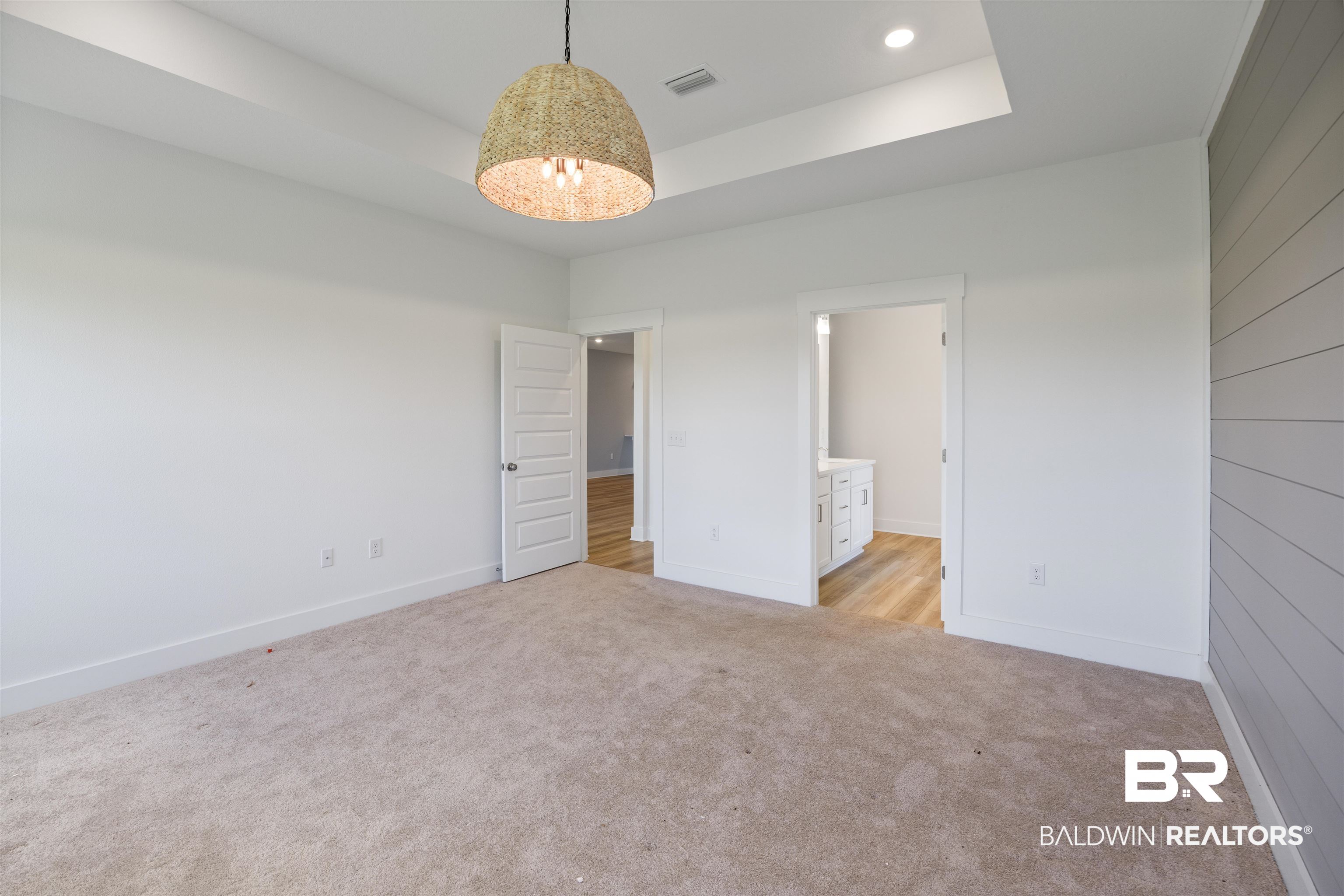 9986 Weller Cove Foley, AL 36535 - Photo 20 of 43 Unfurnished bedroom with a tray ceiling, light carpet, connected bathroom, and recessed lighting