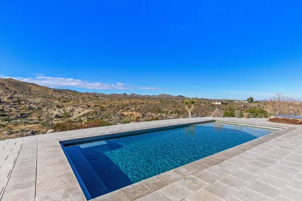 a view of a house with swimming pool and sitting area