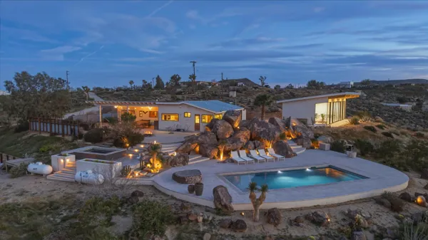 an aerial view of a house with a mountain