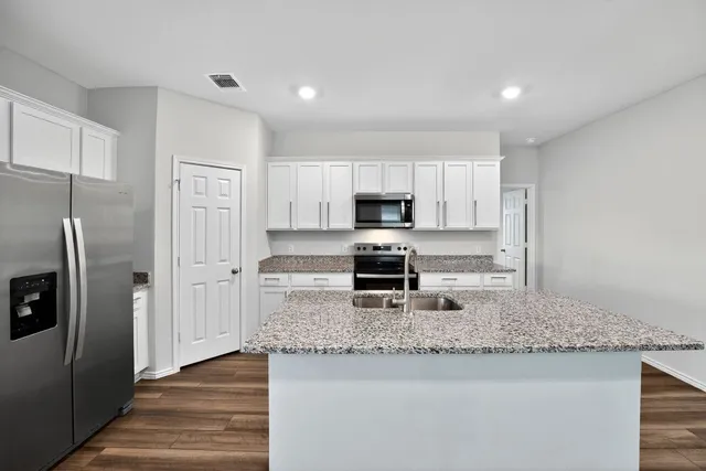 a kitchen with stainless steel appliances granite countertop a sink stove microwave and cabinets