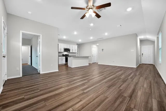 a view of a kitchen with a sink and wooden floor