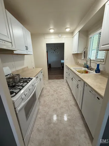 a large kitchen with stainless steel appliances granite countertop a stove a sink and a microwave