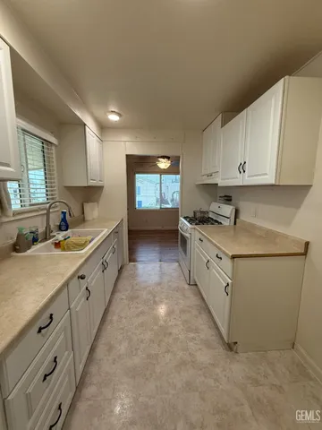 a kitchen with granite countertop white cabinets and white appliances
