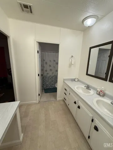 a bathroom with a double vanity sink a mirror and a shower