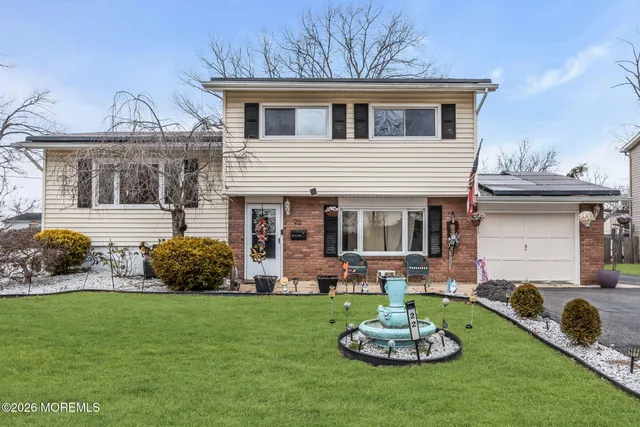 a front view of a house with a garden and plants