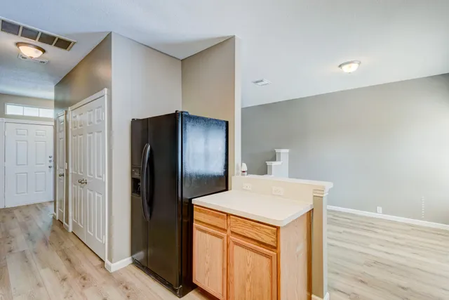 a kitchen view with granite countertop a refrigerator and a sink
