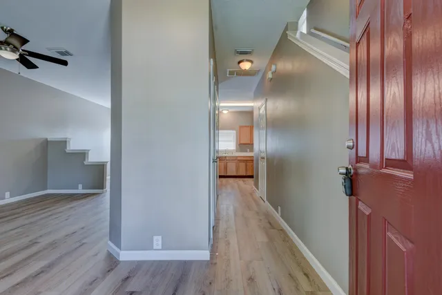 a view of a hallway with wooden floor