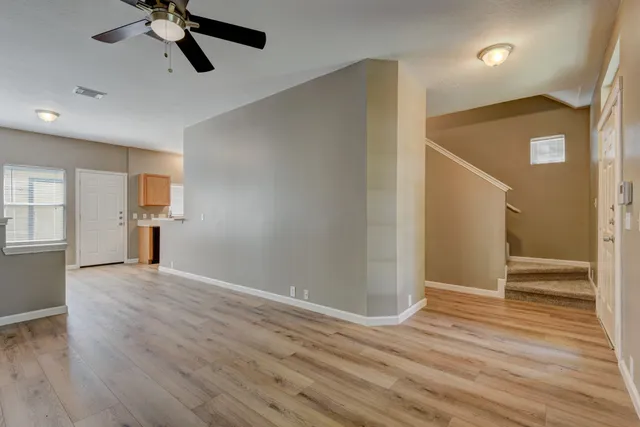 a view of empty room with wooden floor and window