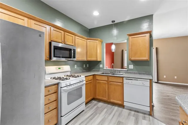 a kitchen with stainless steel appliances granite countertop a stove a sink and a microwave