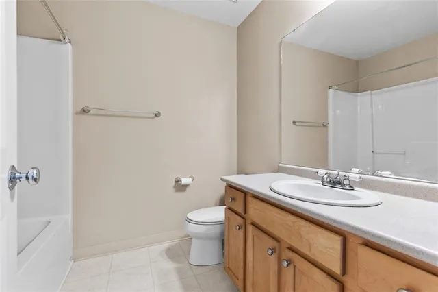 a bathroom with a granite countertop sink a toilet and a mirror