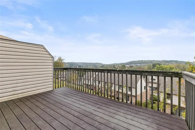 a view of balcony with wooden floor and fence