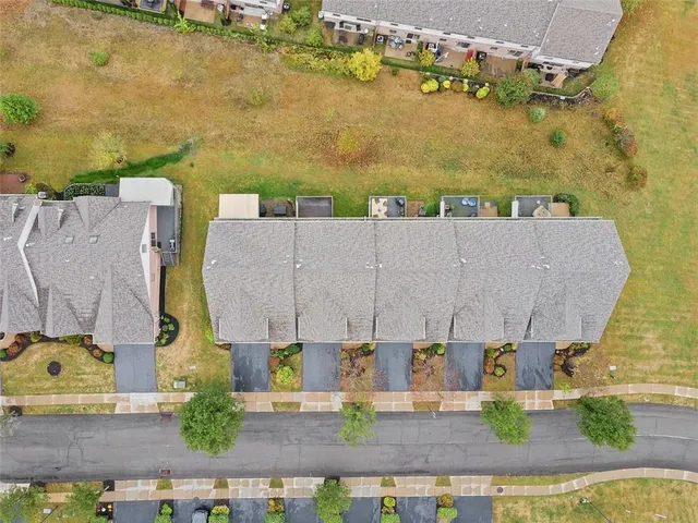 an aerial view of residential houses with outdoor space and parking