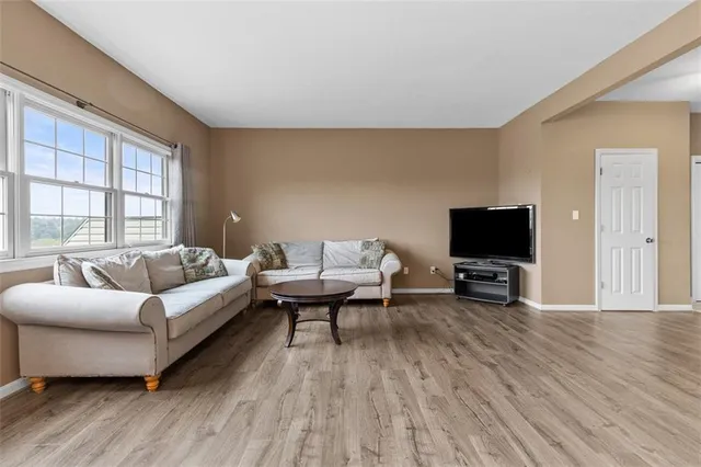 a living room with furniture a flat screen tv and a wooden floor