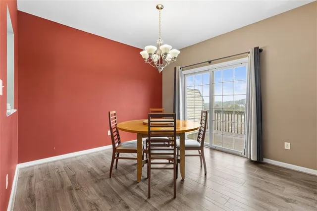 a dining room with furniture a chandelier and wooden floor