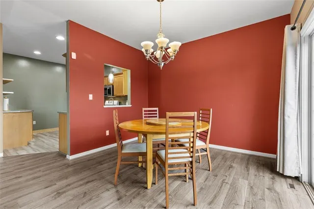 a dining room with furniture a chandelier and wooden floor