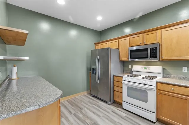a kitchen with stainless steel appliances kitchen island granite countertop a stove a sink and a microwave