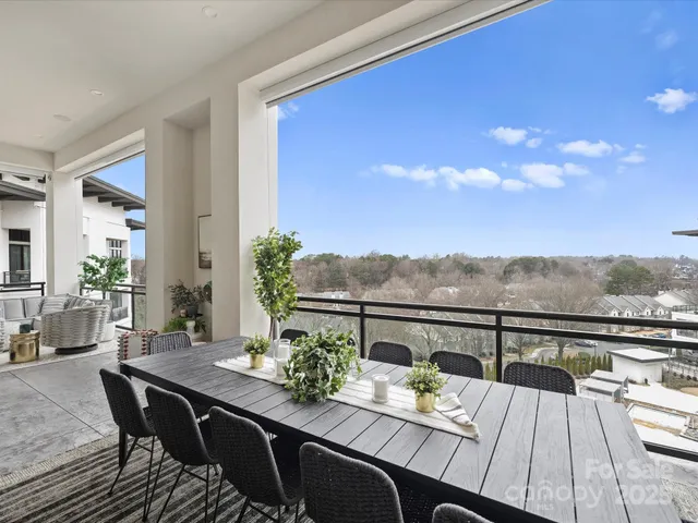 a view of a balcony with dining table and chairs with wooden floor and fence
